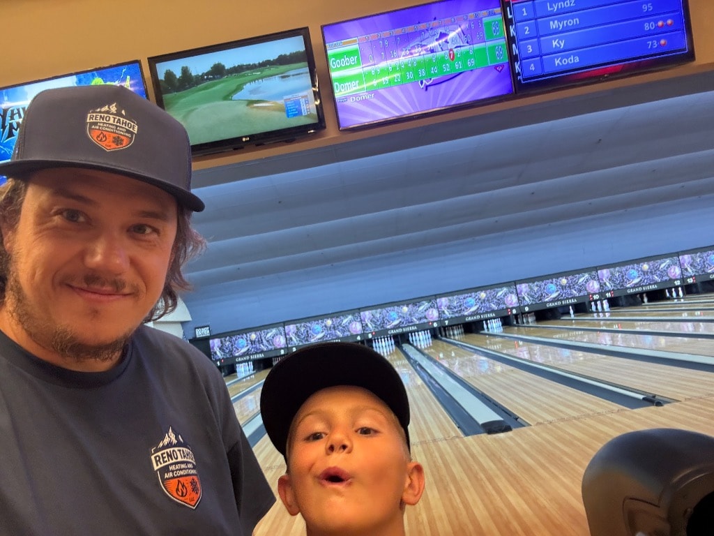 Ryan Otte and his son at the Grand Sierra bowling alley, both wearing Reno Tahoe Heating and Air gear